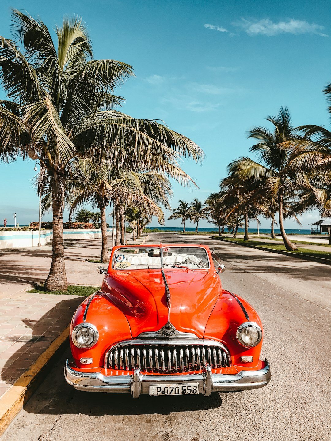 Vintage convertible automobile driving along a rural coastal road near Jose Ignacio