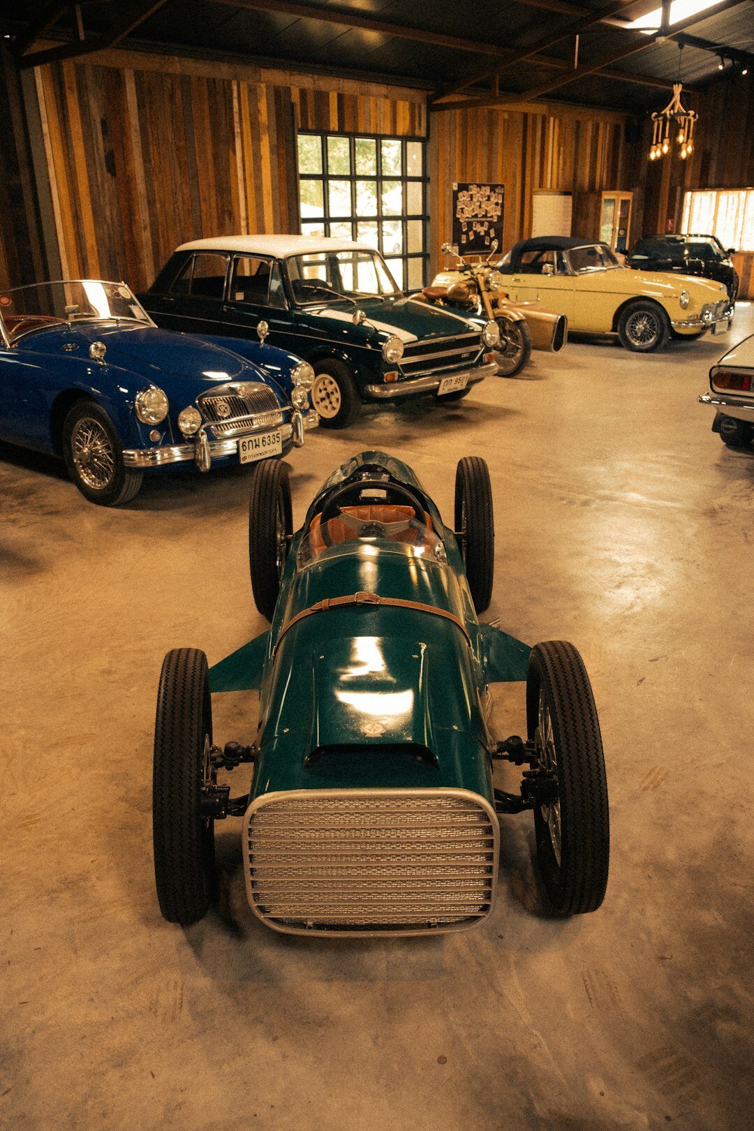 Wide view of a secret private collection garage with dozens of classic automobiles
